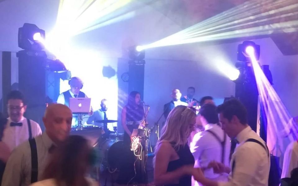 Invitados bailando con luces robóticas en una fiesta