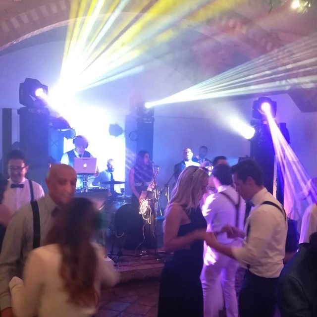 Invitados bailando con luces robóticas en una fiesta