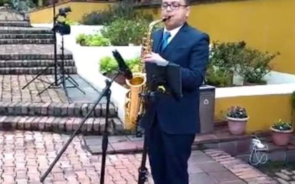 Saxofonista tocando en una ceremonia al aire libre