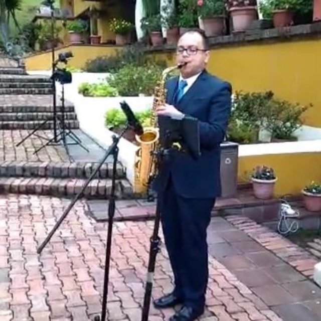 Saxofonista tocando en una ceremonia al aire libre