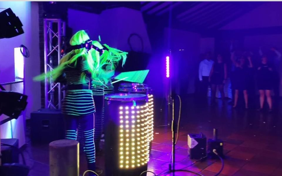 Show con luces neón y DJ en una fiesta