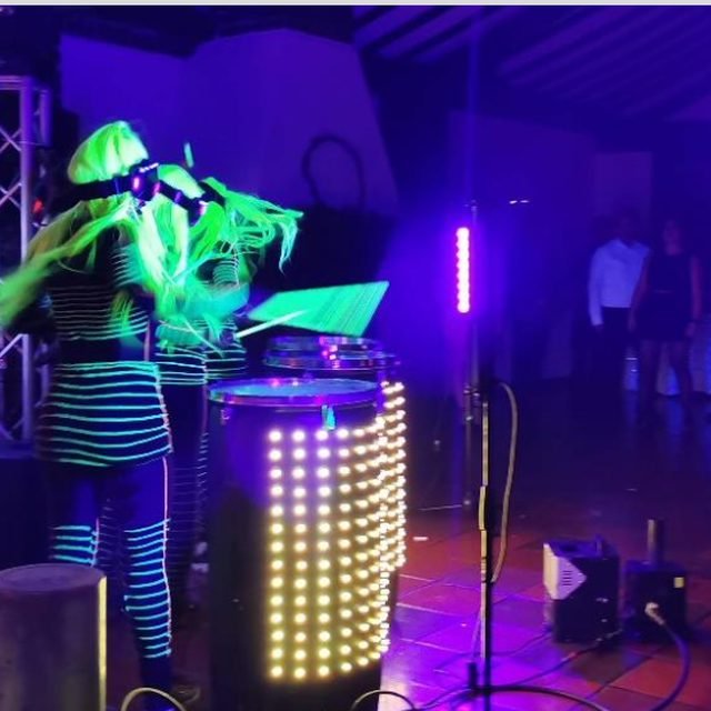 Show con luces neón y DJ en una fiesta